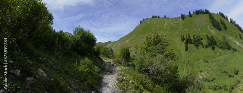 Panorama grüne Hügel mit Weg und blauem Himmel mit Wolken