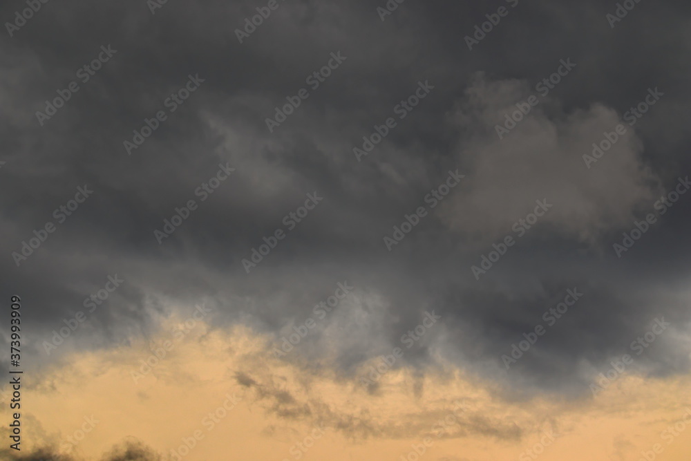 stormy clouds in varying shades of gray, floating under the dusk sky.