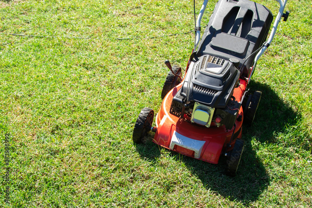 Fototapeta premium lawn mower on the grass with copy space, agricultural and gardening machinery