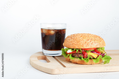  burger and cola on cutting board on white background