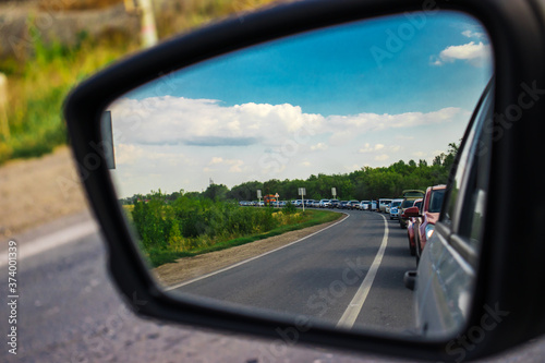 View in the rear mirror of a car, a long traffic jam on the road