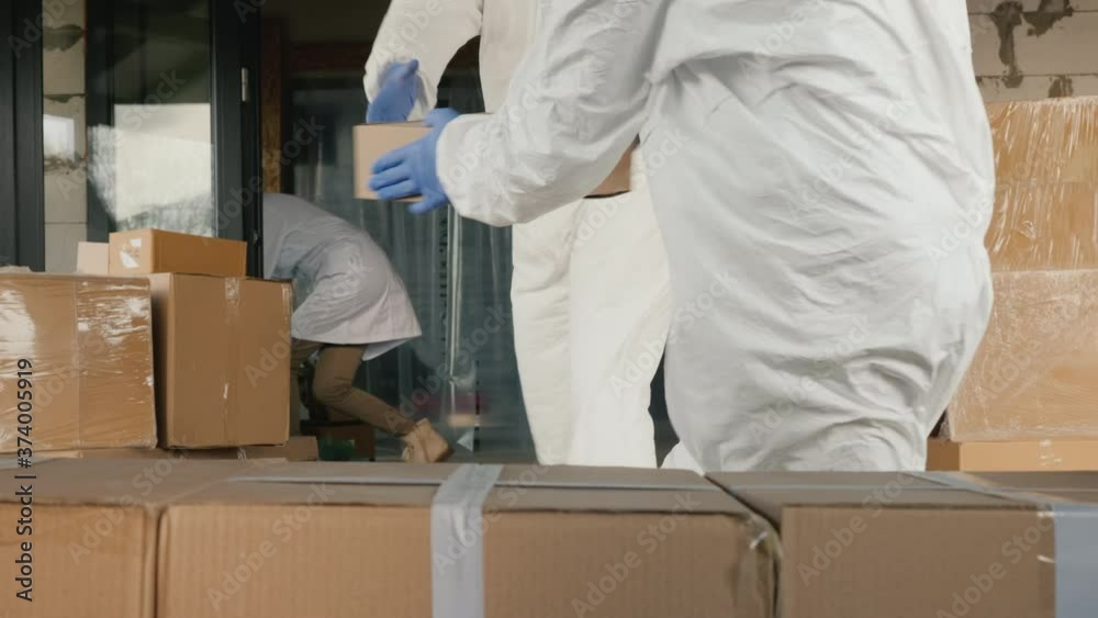 Carriers in antiviral suits unload boxes of medicines