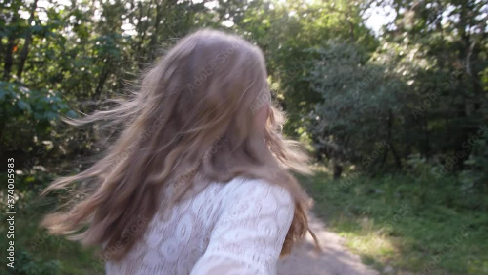Beautiful young blond woman in white dress in love runs and smiles in forest slow-motion Beautiful young blond woman in white dress in love runs and smiles in forest slow-motion