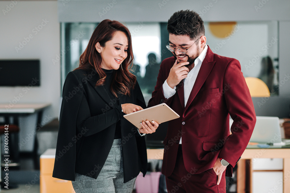 Latin business couple with arms crossed at the office in Mexico Latin business couple with arms crossed at the office in Mexico
