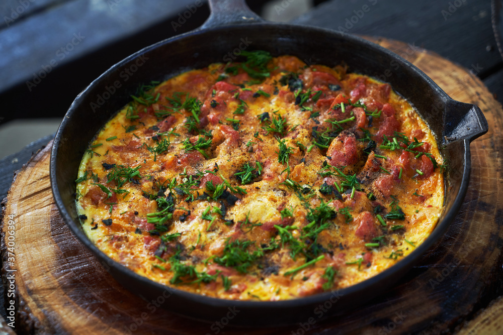 Shakshuka breakfast with fried egg and tomato in a pan