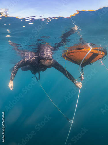 Freediver in ocean next buoy and rope