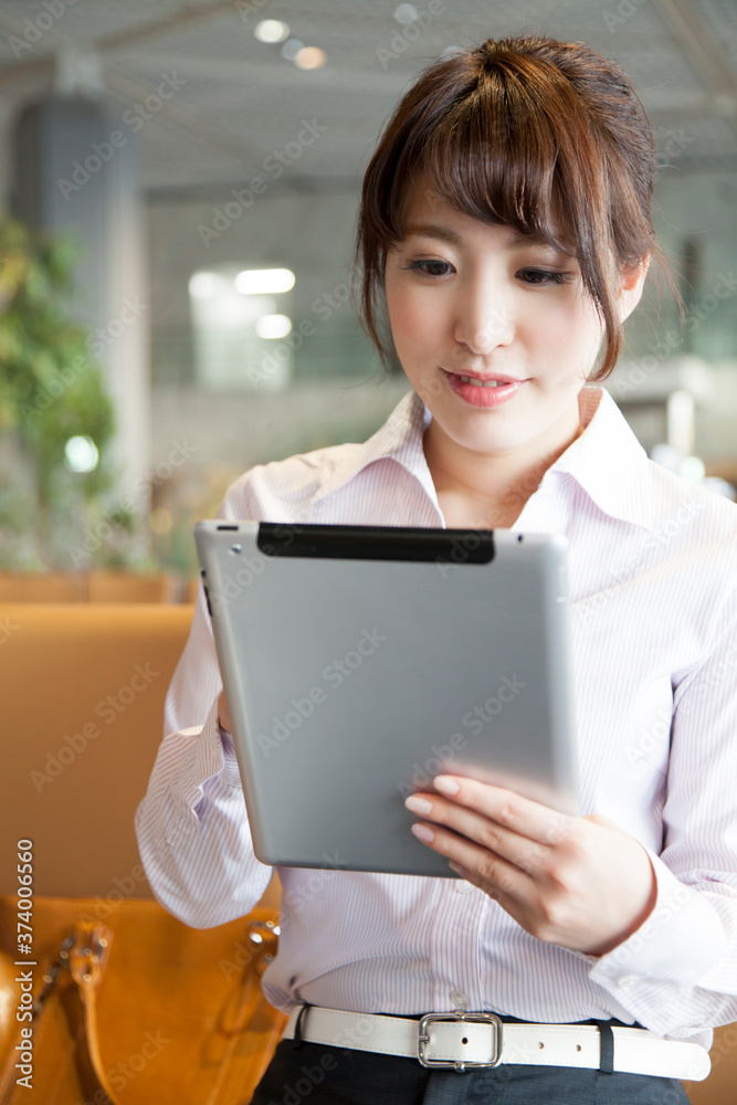 Fototapeta premium 空港でタブレットPCを操作するOL