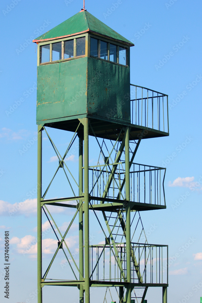 Old metal watchtower against blue sky