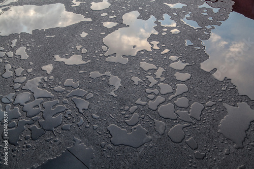 Puddle of water on new asphalt texture background