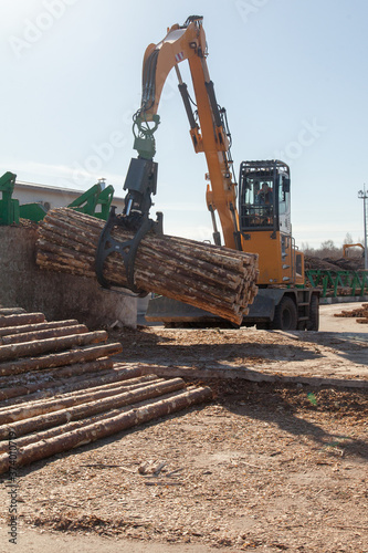 Industrial loader transports logs at a sawmill