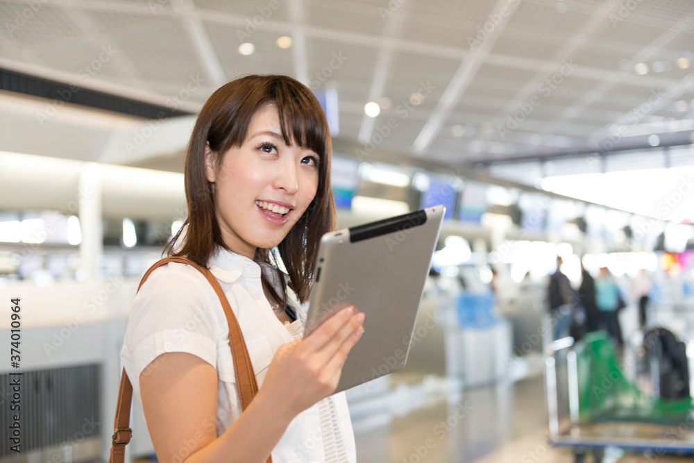 空港でタブレットPCを見る女性