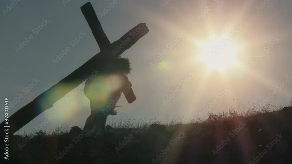 Jesus with crown of thorns carrying a heavy cross