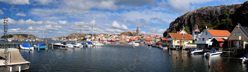 Panoramic View From The Harbour To Fjallbacka Town On A Sunny Summer Day With Some Clouds In The Sky