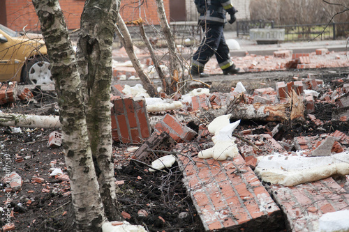 Russian rescuers at the site of the collapse of the wall of a brick apartment building. Destroyed car photo