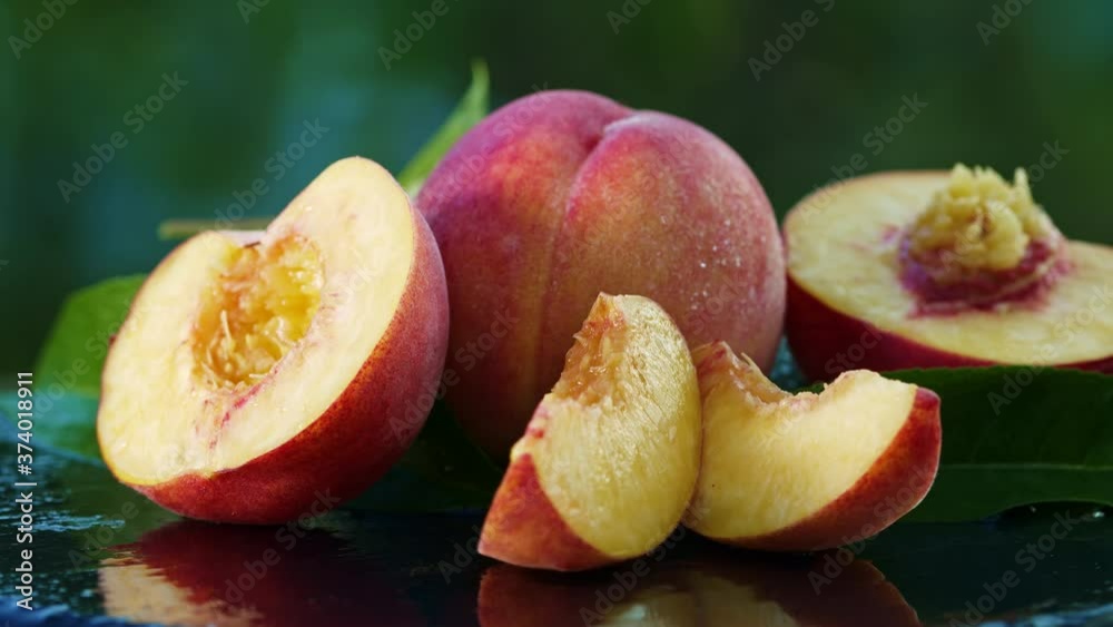 Ripe peaches rotating on black surface with water drops or dew. Abstract organic backdrop. Juicy peach. Healthy eating, agriculture, farm, vitamins concept