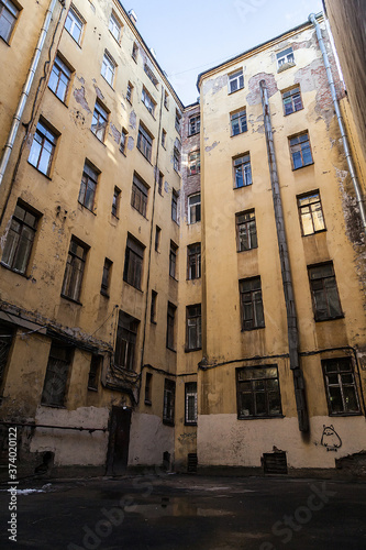 The courtyard of an old apartment building in St. Petersburg with yellow shabby walls