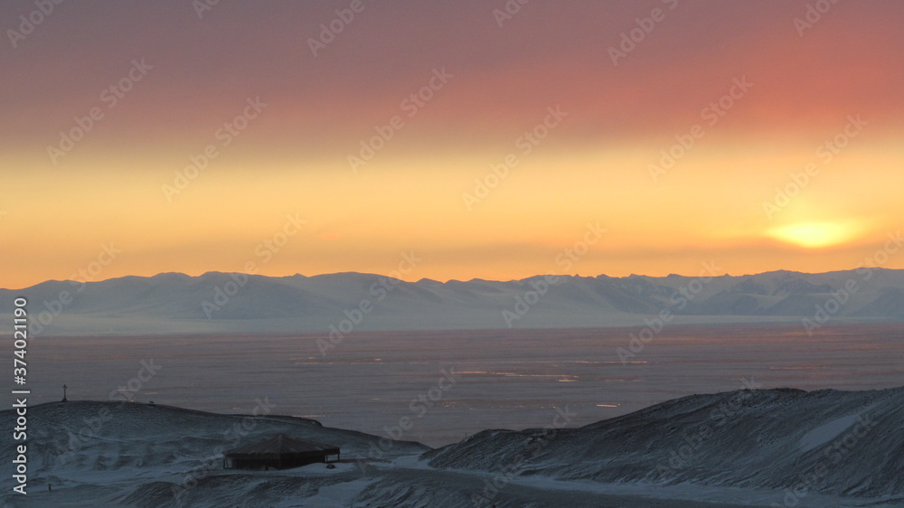 Sunset in Antarctica, behind TransAntarctic Mountains, view of Hut Point and Discovery Hut, near McMurdo Station, Antarctica
