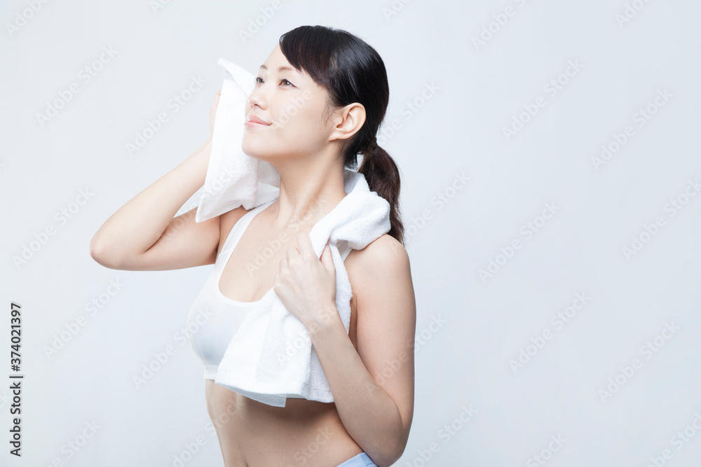 Fototapeta premium タオルで汗を拭く女性