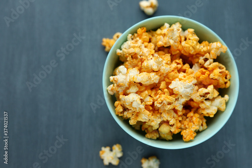 Delicious popcorn in a blue dish on a gray background. Selective focus. Space for text. Copy space