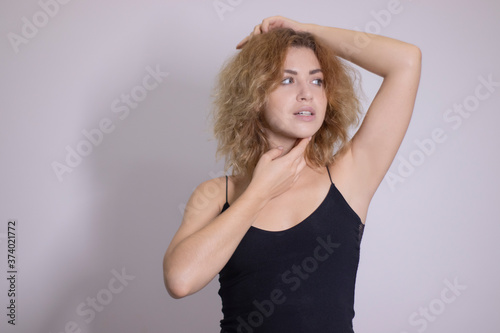 emotional portrait of a beautiful curly blonde-redhead in black undershirt. High quality photo