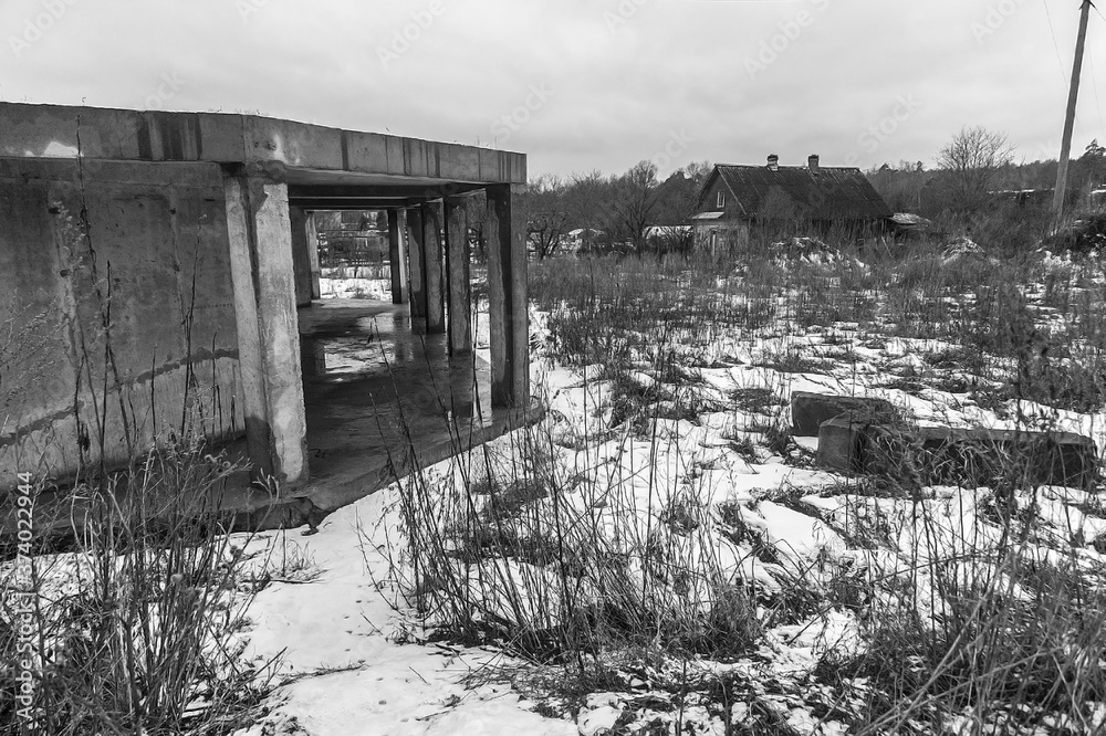 Unfinished concrete house on the banks of a frozen river