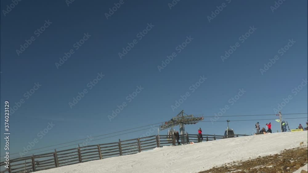 active tourists in warm suits ride skies and skateboards along snowy slope at popular mountain resort on nice winter day timelapse active tourists in warm suits ride skies and skateboards along snowy slope at popular mountain resort on nice winter day timelapse