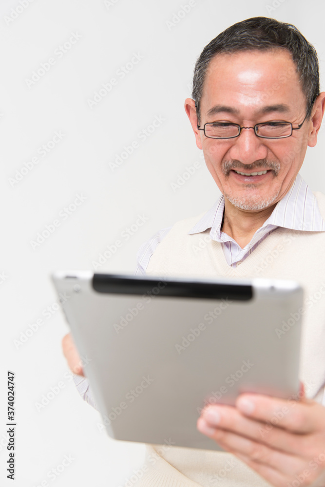 タブレットPCを見るシニア男性