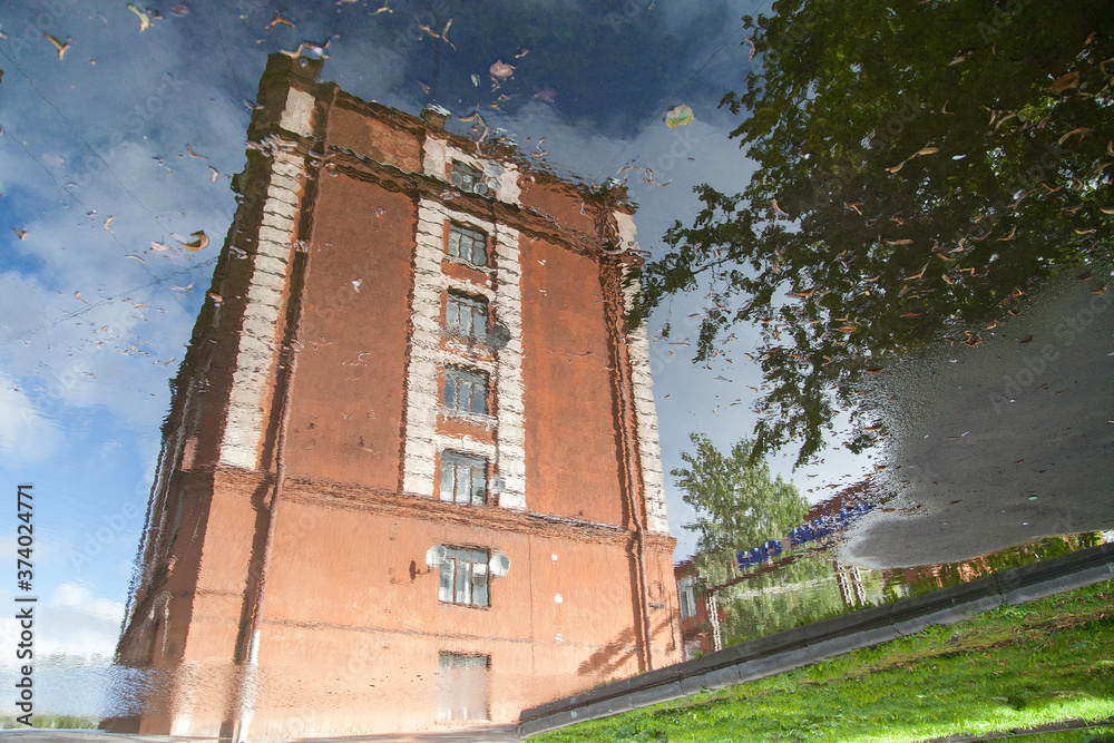 Puddle reflection of vintage building made from red brick