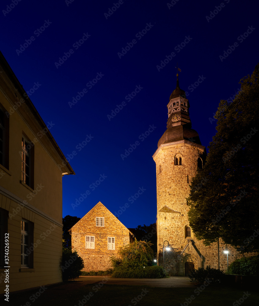 scenic night view of the tower of the church St. Viti and the historic former monastery in Zeven (Germany)