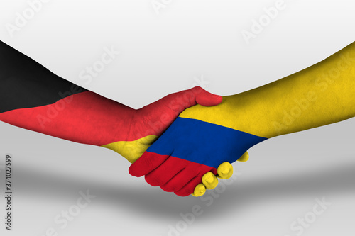 Handshake between columbia and germany flags painted on hands, illustration with clipping path.