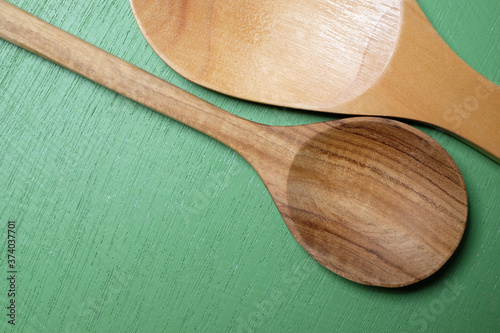 Wooden spoon on a green wooden background.