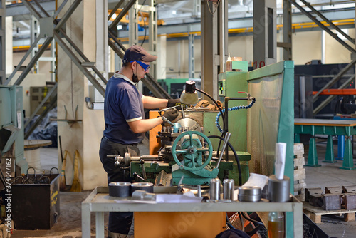 A working turner sets a part on a lathe.