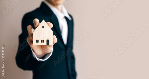 Business realtor man holding home model for investment