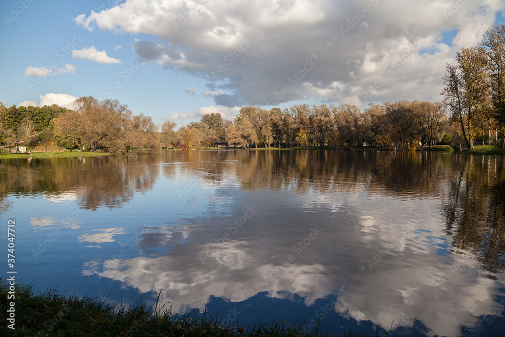 Small lake autumn park landscape with bright trees