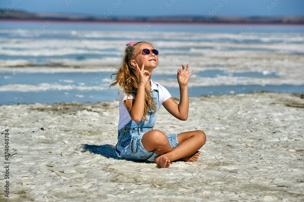 A little girl is engaged in yoga and meditation at a Spa resort . Concept of children's health recreation A little girl is engaged in yoga and meditation at a Spa resort . Concept of children's health recreation