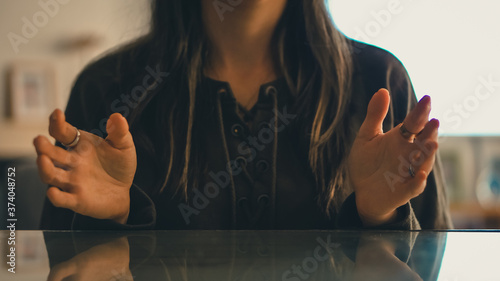 Caucasian woman gesturing with her hands on the table, explaining with her hands