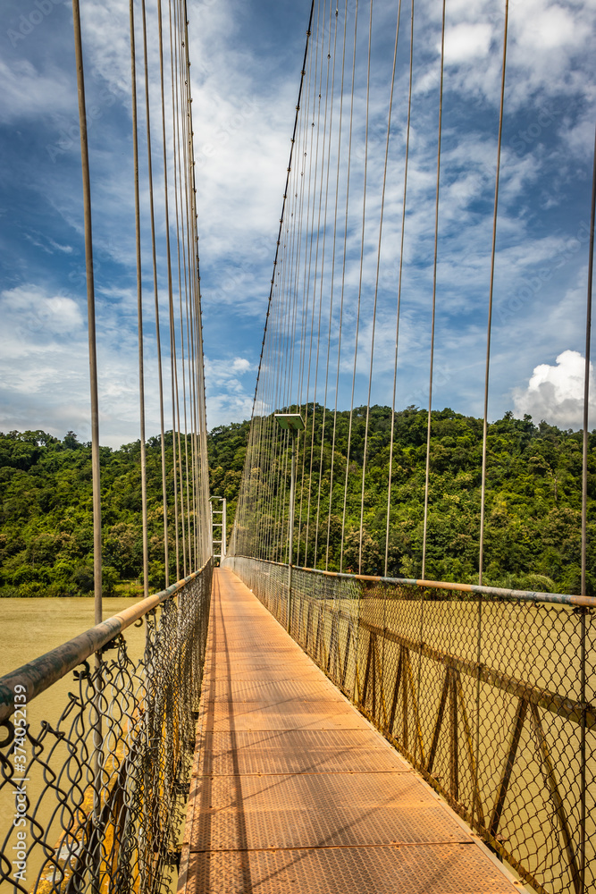Obraz premium suspension iron bridge isolated with bright blue sky from unique different angle