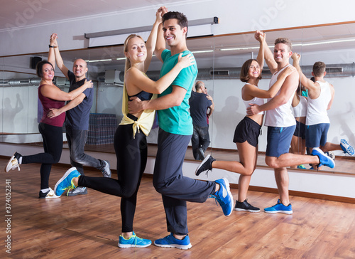 Dancing couples learning swing at dance class