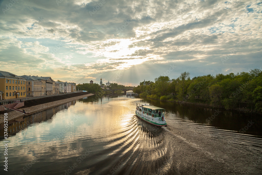 Fototapeta premium Summer townscape with motor ship on a river