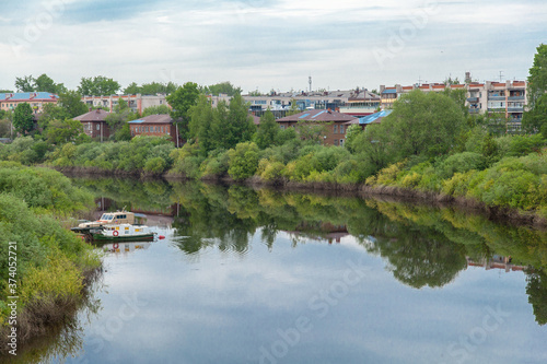 Summer russian river townscape of green embankment