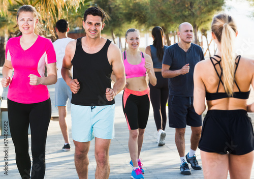 People leading healthy lifestyle, jogging during outdoor workout on city seafront