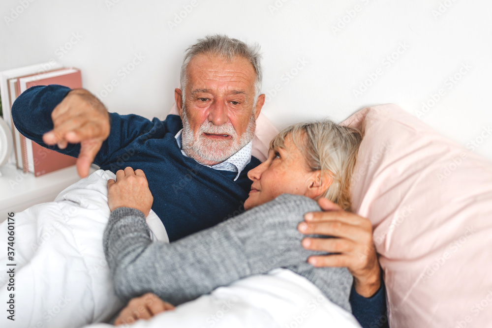 Senior happy couple relaxing and talking together lying on bed in bedroom at home.Retirement couple concept Senior happy couple relaxing and talking together lying on bed in bedroom at home.Retirement couple concept