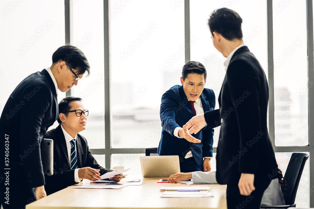Image two asian business partners in elegant suit successful handshake together in modern office.Partnership approval and thanks gesture concept Image two asian business partners in elegant suit successful handshake together in modern office.Partnership approval and thanks gesture concept