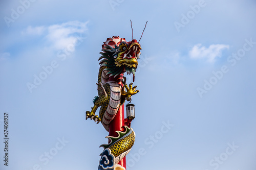 statua di un drago cinese in un cielo blu con le nuvole