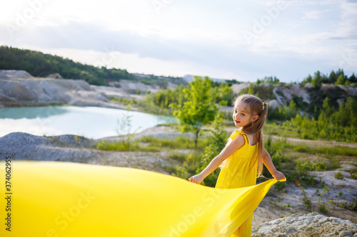 Girl in a yellow dress with wings in a yellow cloth near the lake © Дмитрий Ткачук