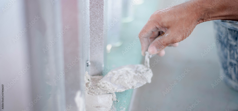 Close up mason hand spreading concrete mix with trowel build the floor and wall. Close up mason hand spreading concrete mix with trowel build the floor and wall.