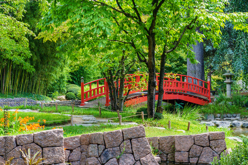 Fototapeta Naklejka Na Ścianę i Meble -  Wooden japanese bridge and shrine in beautiful Albert Kahn Japanese garden in summer - Boulogne-Billancourt near Paris, France