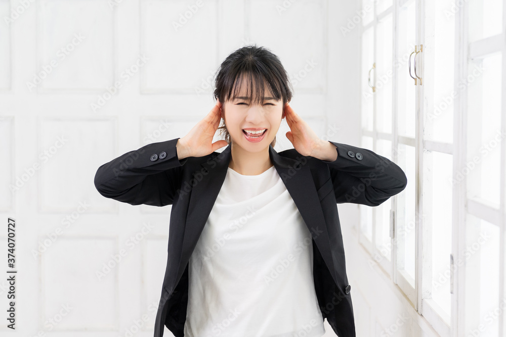 耳を塞ぐ若いビジネスウーマン 耳を塞ぐ若いビジネスウーマン