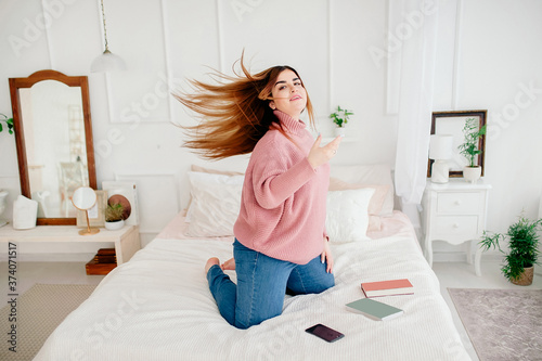 Portrait of a girl of 25-30 years old with straight hair in the air in a white room photo