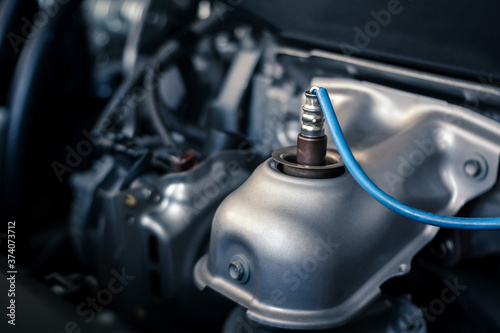 details of modern car engine, O2 oxygen sensor upstream - downstream, shallow depth of field, close up of engine compartment